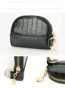 Detail view of mini shell coin purse with crocodile texture and gold hardware zipper
