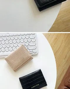 Primer plano de la textura de piedra en carteras de tres pliegues negras y beige