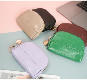 Detail of five-color mini shell coin purses with crocodile texture and gold zippers