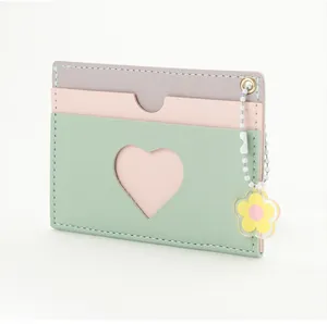 Close-up of multicolor card holder featuring heart cutout and sunflower charm detail
