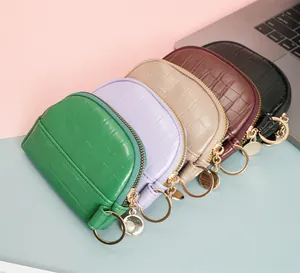 Detail of colorful crocodile pattern mini shell purses with gold key rings and zippers