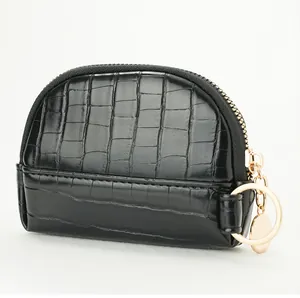 Detailed view of black crocodile pattern coin purse with gold zipper and key ring