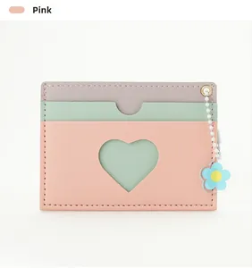 Detailed view of pink pastel card holder with heart window and blue flower charm