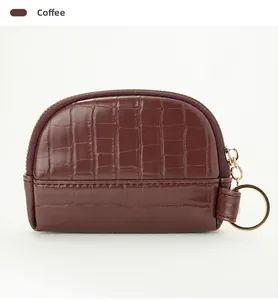 Detail of coffee brown shell coin purse with stone pattern and metal keychain