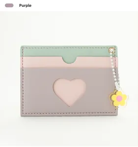 Detail of purple tricolor wallet with heart cutout and yellow flower charm decoration