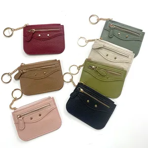 Detail showing seven multi-colored leather coin purses with metallic studs and keychains