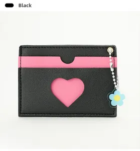 Detail of black faux leather card holder with heart cutout and blue flower pendant