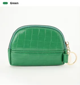Macro detail of emerald green stone pattern coin purse with gold zipper and key ring