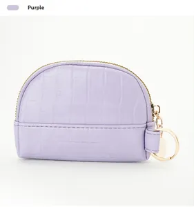 Detail of purple shell coin purse with crocodile texture and gold metal keychain