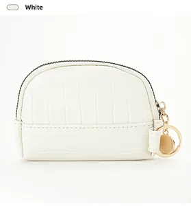 Detailed macro view of white crocodile pattern shell purse with gold zipper and keychain