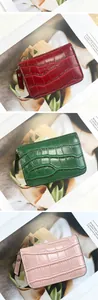 Détail de trois porte-cartes à motif crocodile en rouge, vert et rose avec fermetures