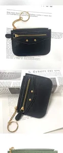 Close-up of black lychee leather wallet with gold zipper and keyring detail
