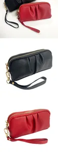 Close-up of ruched vegan leather wristlet bag with dual gold zippers and litchi texture