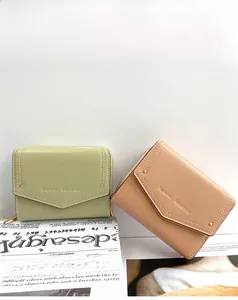 Close-up of PU leather short wallets in light green and pink with envelope flap design