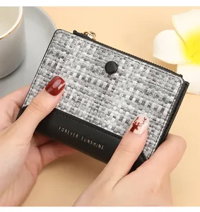 Détail du portefeuille en tissu tissé gris et cuir noir avec fermeture éclair dorée