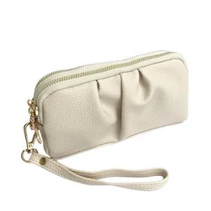 Elegant beige pleated pebbled leather clutch bag with dual golden zippers and wristlet strap