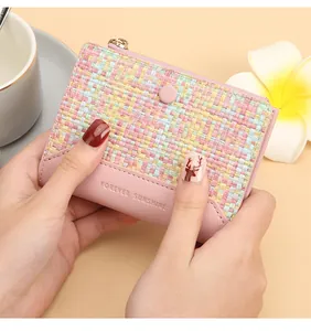 Détail du portefeuille rose tissé avec texte Forever Sunshine et zip doré élégant