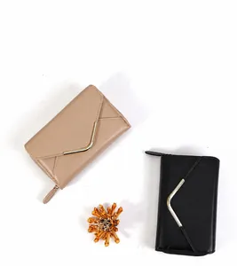 Details minimalistischer Umschlag-Geldbörsen in Beige und Schwarz mit goldenem V-Metall