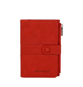 Red RFID blocking passport wallet detail featuring textured faux leather and snap button