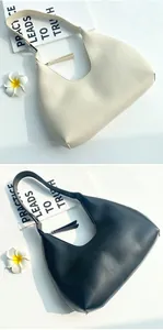 Minimalist half-moon underarm bags in cream and black faux leather with sleek zipper closure