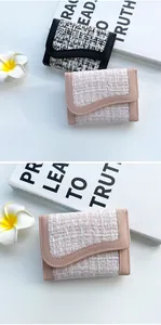 Dettaglio di portafogli in tweed e pelle in rosa e nero dallo stile chic raffinato
