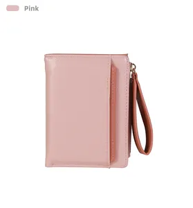 Detail view of pink card wallet showing cross-grain texture, zipper, and wrist strap