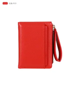 Detail of red cross-grain leather wallet with wrist strap and metal zipper