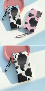 Detail of cow print long wallet with wrist strap and metal zipper for women