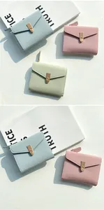Detail of short leather wallets with lychee texture and golden V-shaped metal buckles