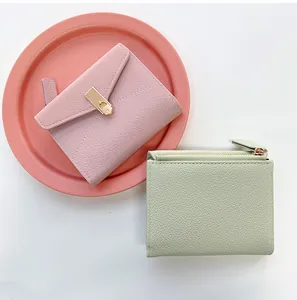 Detail of pink and green pebble leather mini wallets with gold clasp and zipper detail