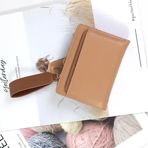 Brown lychee leather women's card holder with wrist strap and gold hardware accents