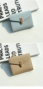 Detailed view of women's leather wallet with pebble grain texture and gold metal buckle