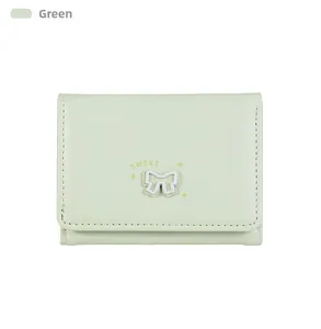 Détail du portefeuille vert menthe avec nœud décoratif et inscription Sweet brodée