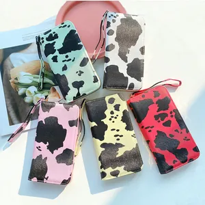 Cow print long zip-around wallets for women in five pastel colors with wrist strap