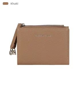 Detailed macro view of khaki leather texture and metal zipper puller on minimalist wallet