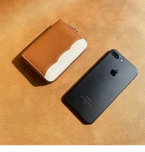 Dettaglio del portamonete compatto in pelle bicolore marrone e bianco con zip