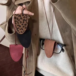 Chic leopard and solid leather magnetic sunglasses holders with neck straps shown on a model