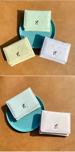 Vue macro du portefeuille vert menthe avec gaufrage carotte et détail lapin doré