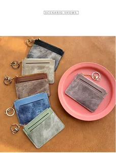 Detailed view of six textured leather card holders with zippers and metal keyrings