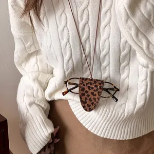 Chic leopard print leather glasses holder pendant worn over a cozy cream knit sweater