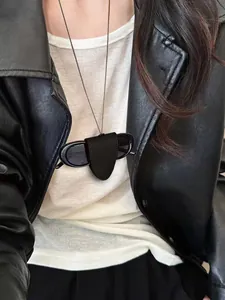 Detail of a black leather neck-hanging sunglasses holder with minimalist stitching