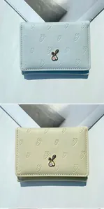 Détail de portefeuilles courts à trois volets en bleu pastel et crème avec lapin