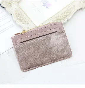 Detail of rose pink leather card holder with metallic fabric trim and top zipper closure