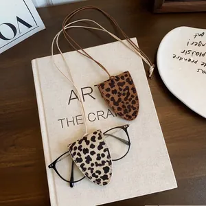 Leopard print magnetic eyewear clip and lanyard details on a minimalist aesthetic desk