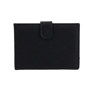 Minimalist black lychee leather passport wallet with a secure strap closure for travel