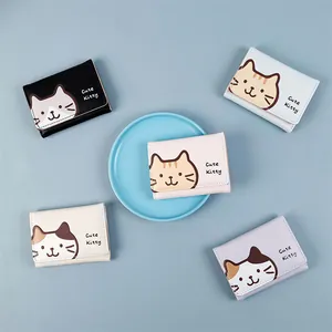 Flat lay of five colorful trifold cat wallets arranged on a light blue display tray