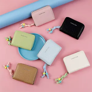 Flat lay of colorful textured PU leather coin purses with beaded zipper pulls and branding