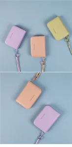 Macro detail of macaron leather wallets with zip, round buckle and wrist strap