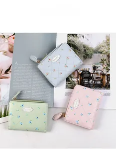 Gros plan détaillé des portefeuilles floraux macaron avec surpiqûres et zip