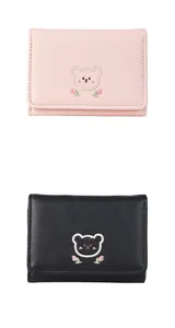 Close-up of cute bear embroidery and texture on pink and black PU leather wallets